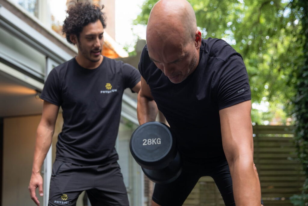 Personal trainer met cliënt tijdens training in de tuin